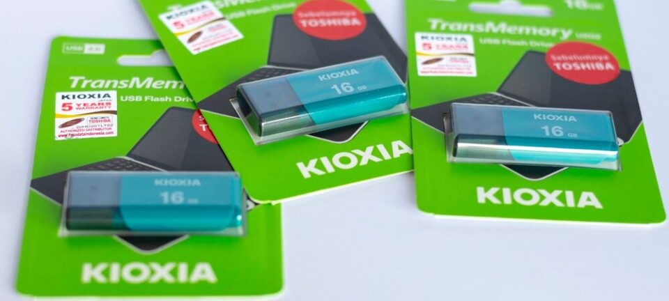 Three Kioxia TransMemory 16 GB USB flash drives in packaging on white surface